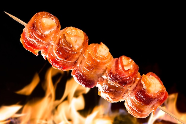 Brochette de poulet au bacon sur des flammes de feu