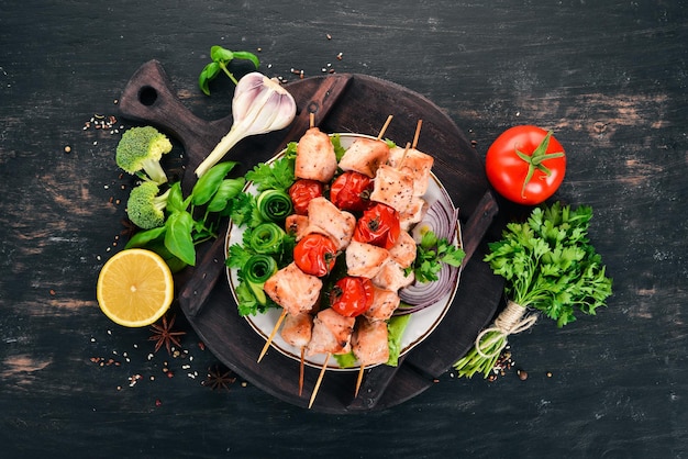 Brochette de poulet aux tomates cerises et légumes Sur un fond en bois Vue de dessus Espace de copie