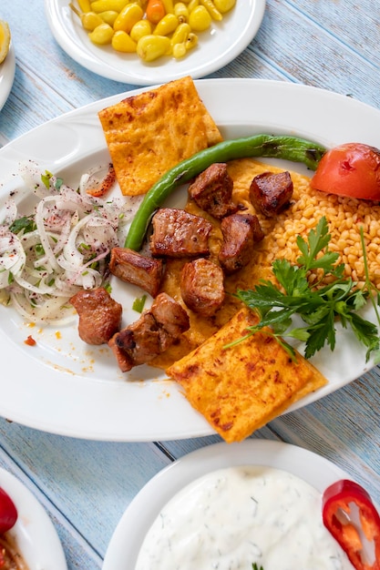 Brochette de shish de viande dans une assiette avec des amuse-gueules