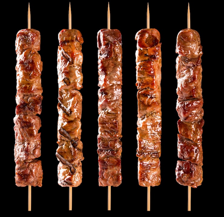 Photo brochette de viande sur un espace noir.