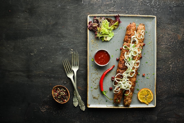 Brochette de viande traditionnelle de boeuf ou d'agneau haché avec légumes et herbes. Aliments. Vue de dessus. Espace libre pour votre texte.