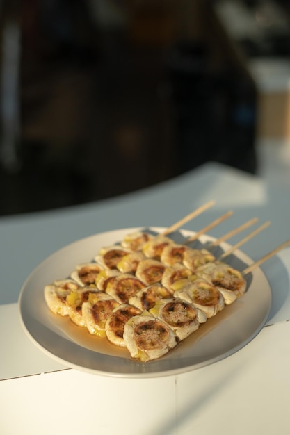 Brochettes de bananes grillées garnies d'une sauce sucrée sur une assiette blanche