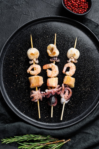 Brochettes en bois avec crevettes, poulpes, calamars et moules Brochette de fruits de mer. Vue de dessus