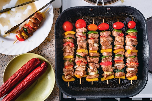 Brochettes grillées sur des bâtons en bois, viande de porc et légumes sur le gril.