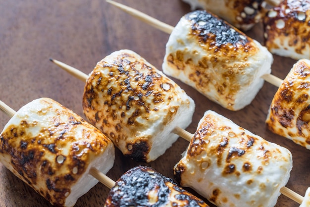 Brochettes de guimauve sur la surface en bois