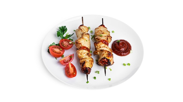 Photo brochettes de poulet aux légumes sur plaque blanche isolé sur blanc. souvlaki isolé.