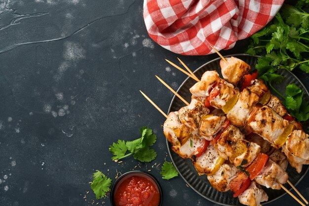 Brochettes de poulet ou brochettes de brochettes dans une assiette en céramique, épices, herbes de coriandre et légumes sur fond de tableau blanc. Barbecue Ingrédients crus pour goulasch ou shish kebab. Vue de dessus. Espace copie gratuit