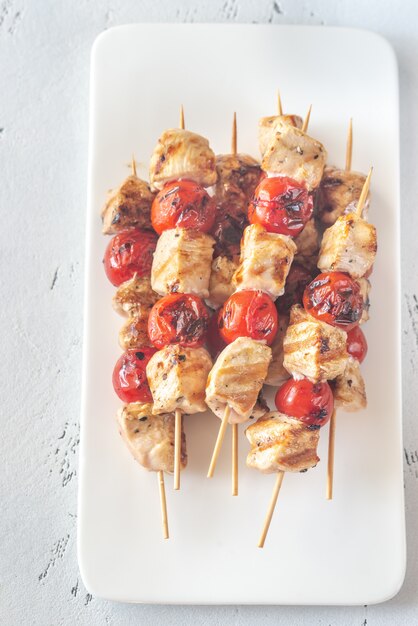 Brochettes de poulet grillé sur la plaque blanche