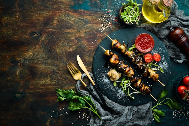 Brochettes de Rapana avec des légumes sur une plaque en pierre noire Restaurant de fruits de mer Style rustique Mise à plat