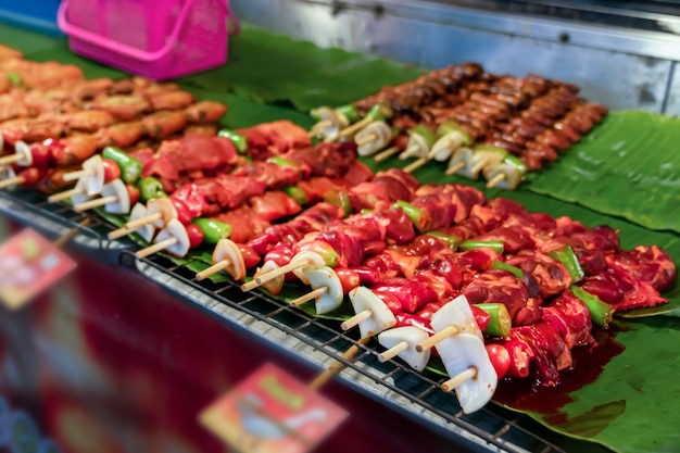 Brochettes rouges crues aux oignons de viande de canard et de poulet et de porc sur le marché de rue de Phuket. cuisine de rue traditionnelle thaïlandaise