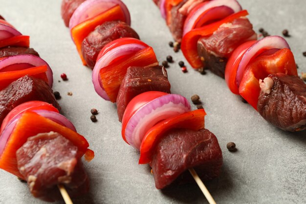 Brochettes avec shish kebab cru sur table grise