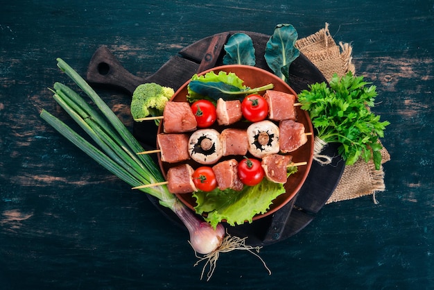 Brochettes de viande crue sur une assiette Sur un fond en bois Vue de dessus Espace de copie