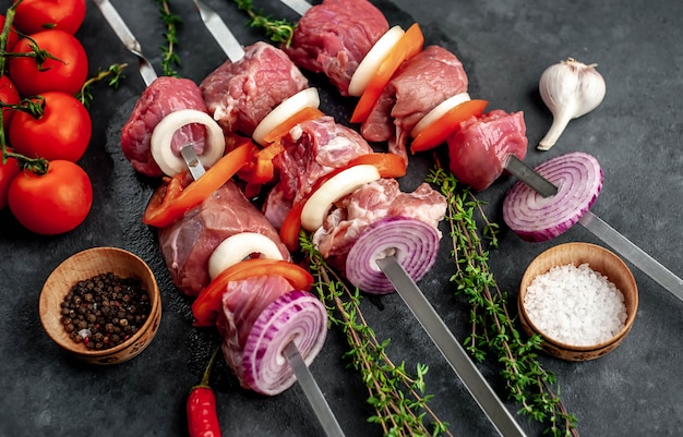 Brochettes de viande crues. Viande barbecue avec légumes et épices.