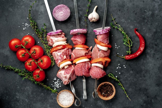 Brochettes de viande crues. Viande barbecue avec légumes et épices.