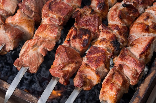 Brochettes de viande sur le gril rôties au feu délicieux rôti de porc en gros plan