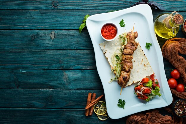 Brochettes de viande grillée avec pain pita et légumes Kebab de viande Plats alimentaires Vue de dessus Espace libre pour votre texte