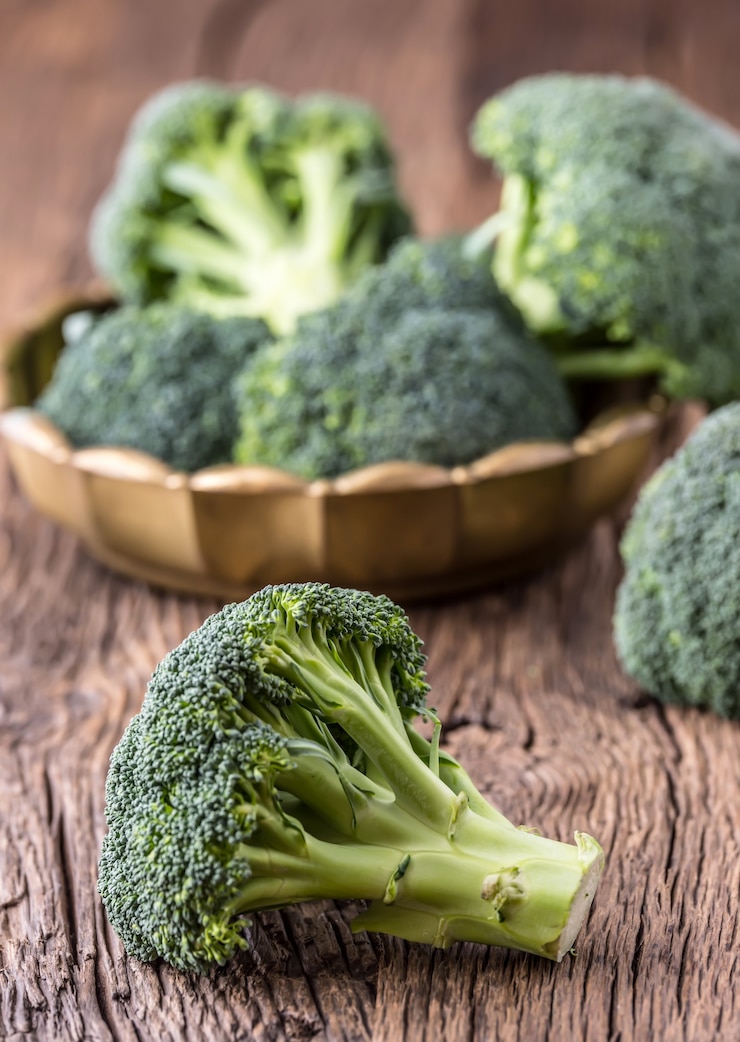Photo brocoli. brocoli frais cru sur la vieille table en bois.