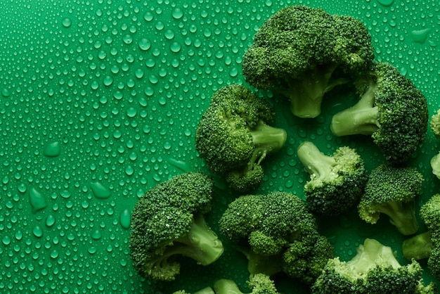 Brocoli cru frais sur fond vert avec espace de copie, vue de dessus. Le concept d'aliments sains, de régime alimentaire, de sulforaphane, de légumes crucifères