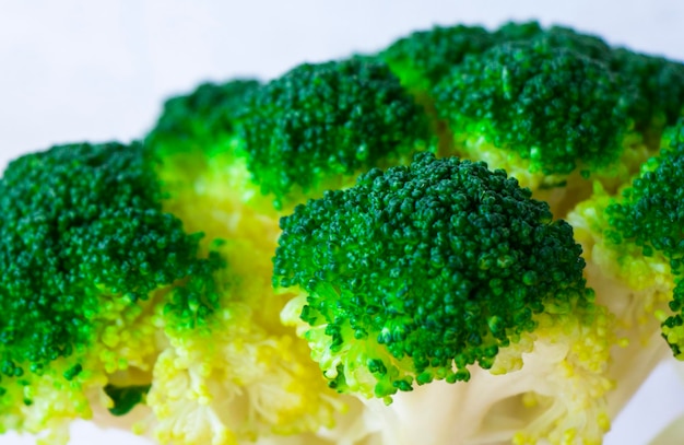 Le brocoli est un légume macro et un gros plan sur un fond blanc de couleur verte.