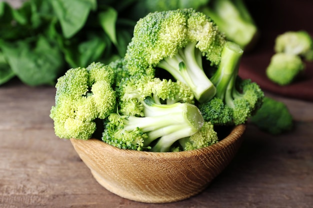 Brocoli frais aux épinards dans un bol sur la table en bois se bouchent