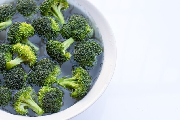 Brocoli frais trempé dans un bol d'eau blanc