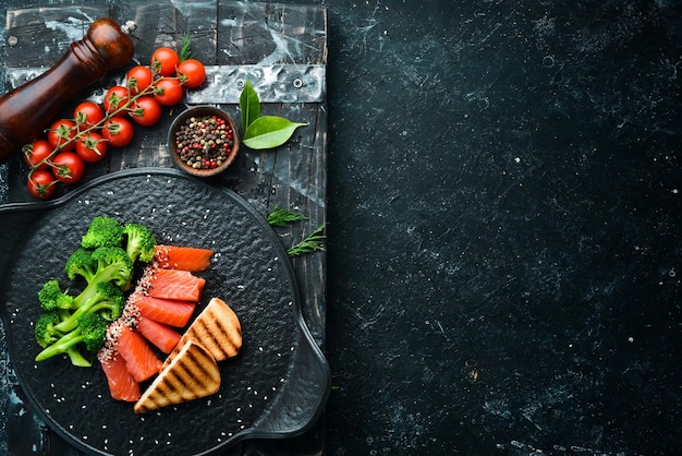 Brocoli et poisson saumon salé Alimentation saine Sur une plaque en pierre noire Vue de dessus