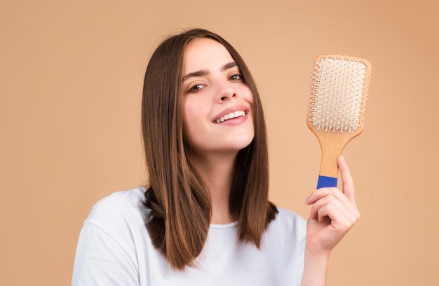 Brossage des cheveux Portrait d'une jeune femme se brossant les cheveux naturels droits avec un peigne Une fille se peignant les cheveux sains avec une brosse à cheveux Concept de beauté de soin des cheveux