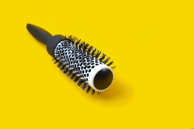 Brosse à cheveux noirs professionnelle sur l'espace de copie de fond jaune