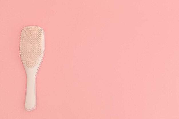 Brosse à cheveux en plastique avec fond rose