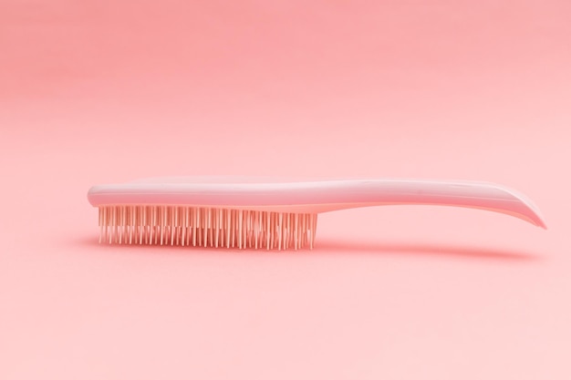 Brosse à cheveux en plastique avec fond rose