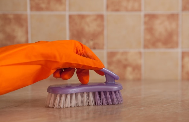 La brosse dans les mains essuie la surface