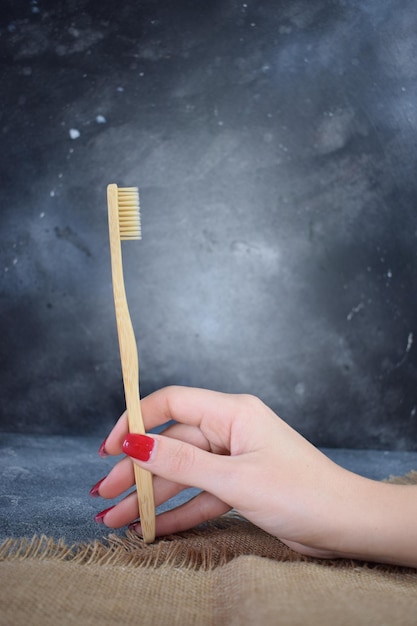 Une brosse à dents en bambou dans la main d'une jeune fille Photo écologique