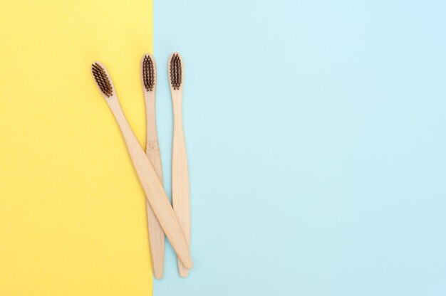 Brosse à dents en bambou sur fond jaune et bleu. Copier l'espace