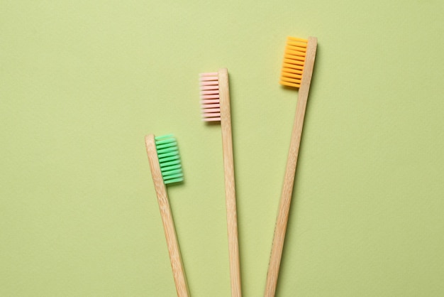 Brosse à dents en bambou sur fond vert. Vue de dessus.