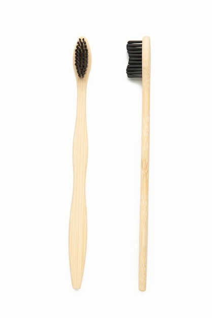 Brosse à dents en bois de bambou avec poils de brosse noirs isolés sur fond blanc