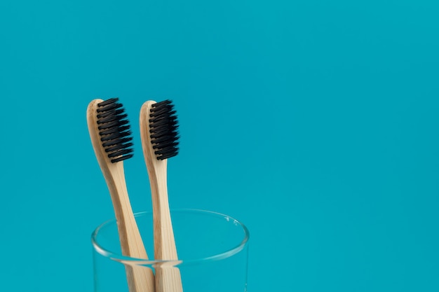 Brosse à dents en bois sur fond bleu dans une tasse