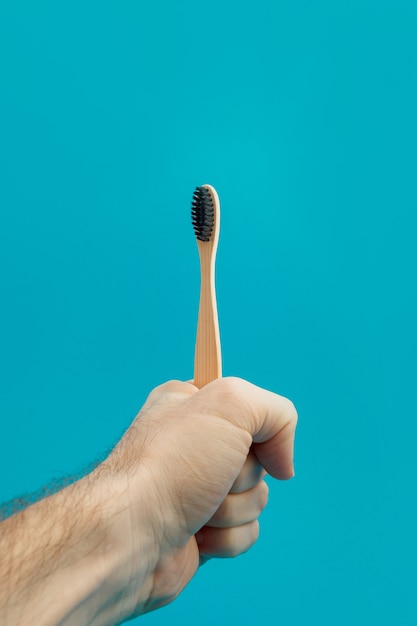 Brosse à dents en bois à la main sur fond bleu