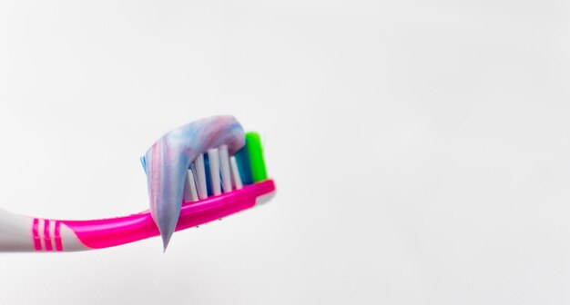 Brosse à dents avec du dentifrice pressé sur fond blanc