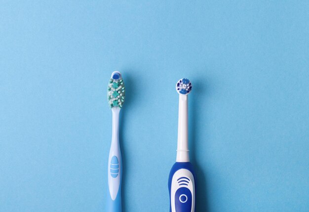 Brosse à dents électrique et classique sur fond bleu