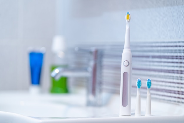 Brosse à dents électrique à ultrasons avec buses interchangeables dans la salle de bain à la maison