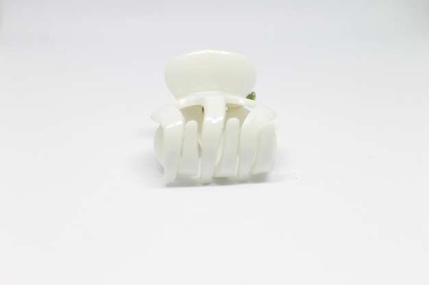 Une brosse à dents en plastique blanc avec une feuille verte dessus.