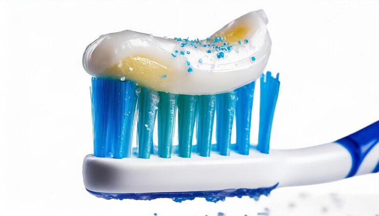 Photo une brosse à dents avec des poils bleus et blancs et un dentifrice bleu