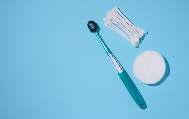 Brosse à dents ronde éponges de coton et cotons-tiges sur fond bleu produits d'hygiène