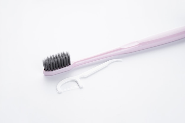 Brosse à dents rose avec un cure-dent blanc sur blanc