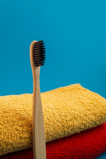 Brosse à dents avec une serviette rouge et jaune sur fond bleu