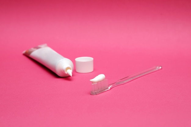 brosse à dents et tube de pâte sur rose