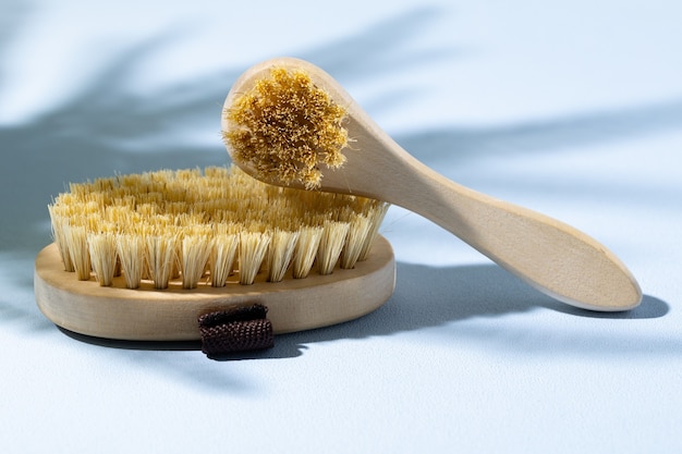 Brosse de massage en bois de soins de la peau sur fond gris