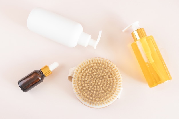 Brosse de massage à sec et bouteilles de cosmétiques