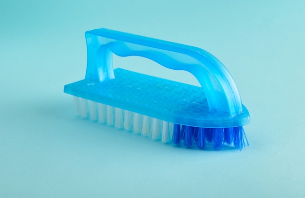 Brosse en plastique bleu pour le nettoyage de la maison.