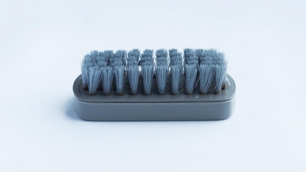 Brosse en plastique de gommage gris multifonctionnel isolé sur fond blanc